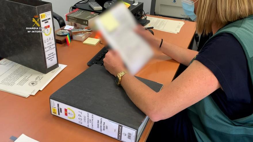 Imagen de una agente de la Guardia Civil revisando papeles.