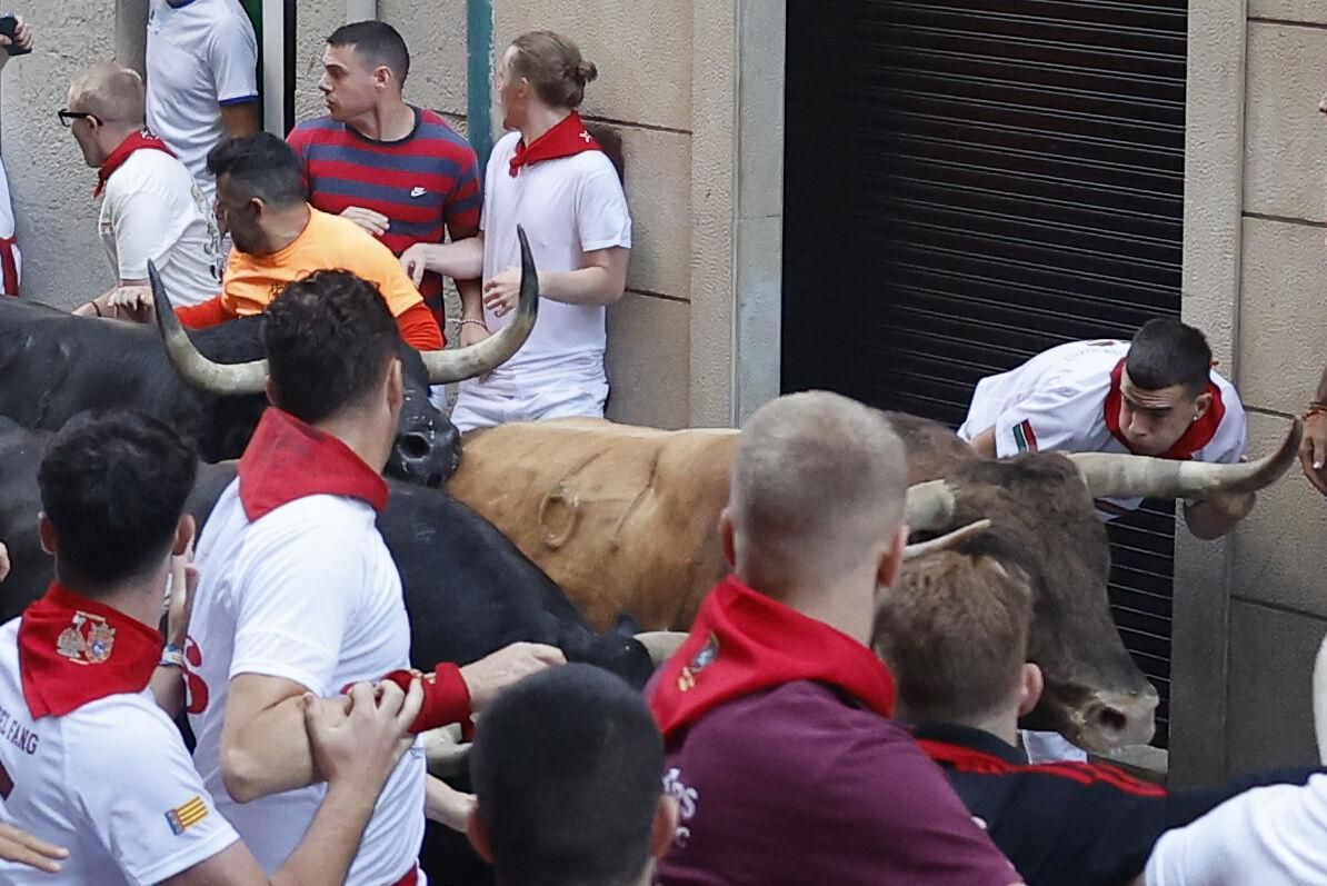 PAMPLONA, 13/07/2025.- Los mozos son perseguidos por toros de la ganadería gaditana de La Palmosilla s durante el séptimo encierro de los Sanfermines 2025 este domingo en Pamplona. EFE/Villar López