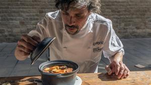 Fran Heras, con un plato de fabada, en su restaurante.