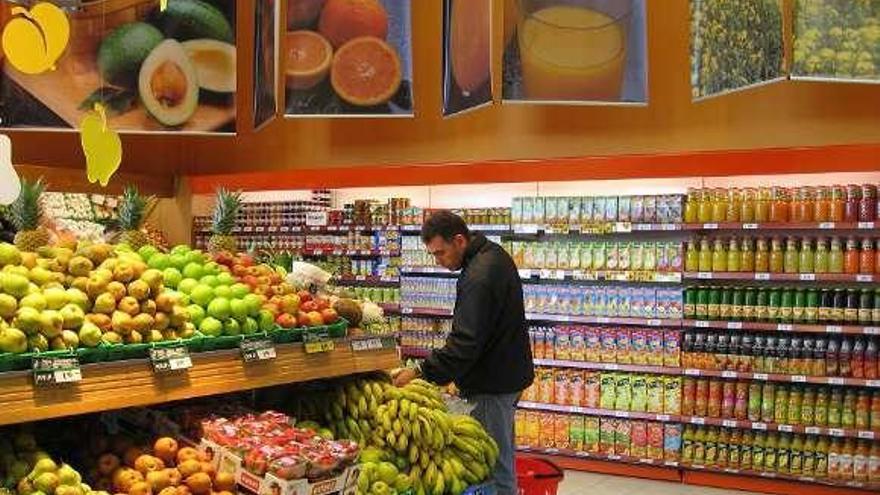Un consumidor en la sección de frutería en un supermercado.