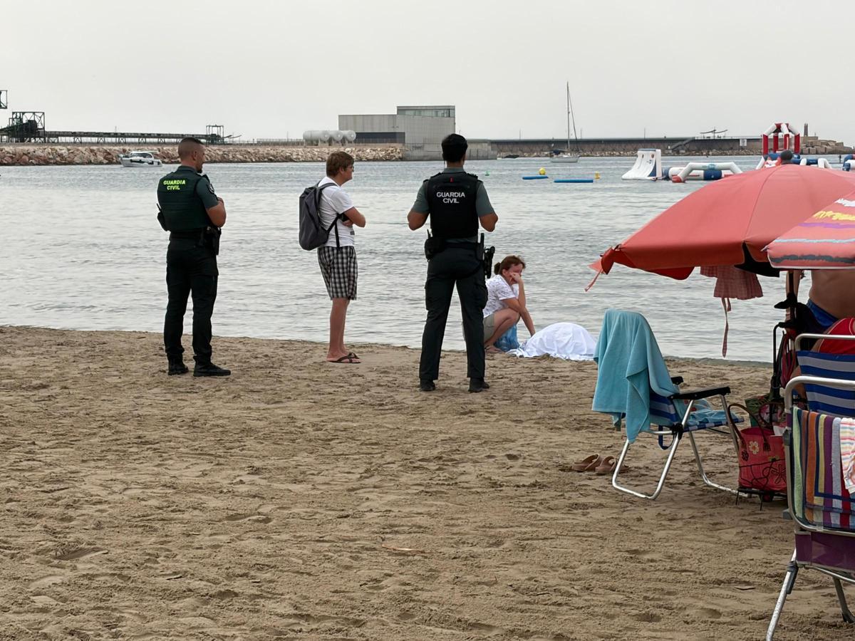 La familia y la Guardia Civil a la espera del levantamiento del cadáver en la playa de Los Náufragos en Torrevieja
