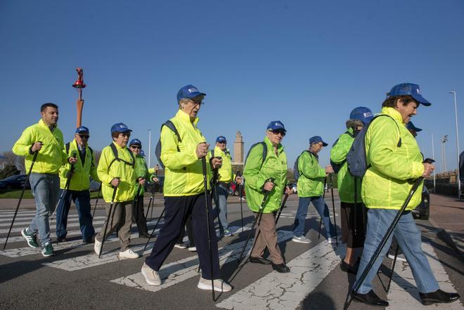 Usuarios y trabajadores del centro residencial Torrente Ballester, en una de sus marchas nórdicas por el paseo marítimo.