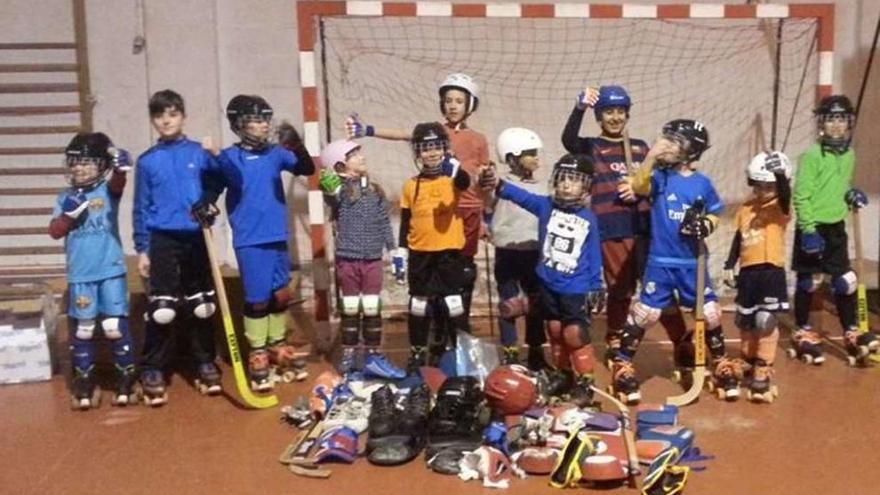 Los niños del Hockey CD Voto posan con el material enviado desde A Coruña.