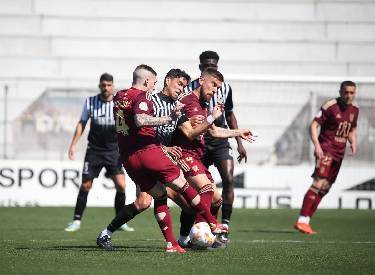 Mancuso y Francis Ferrón intentan arrebatarle el balón a un jugador de la Balompédica Linense, este domingo.