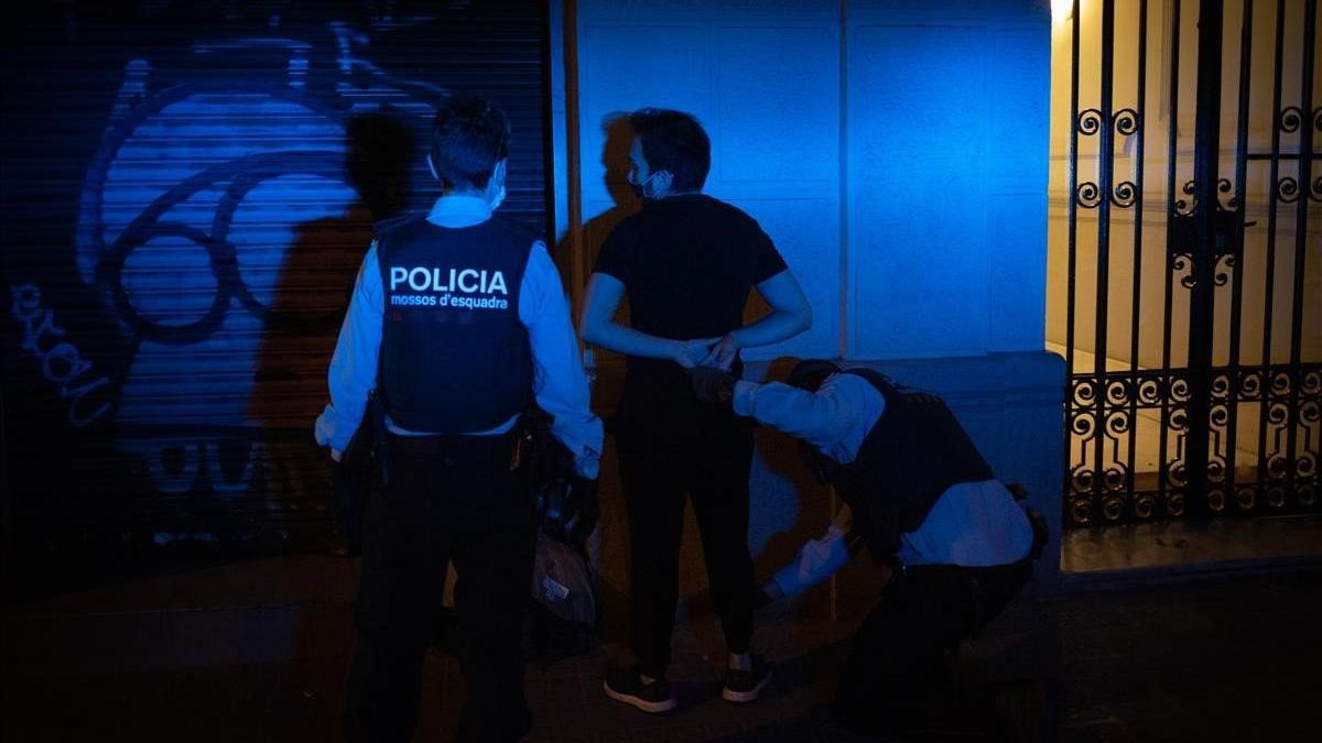 Unos mossos detienen a un hombre que se saltó el toque de queda y se dio a la fuga la noche de este sábado, en Barcelona.