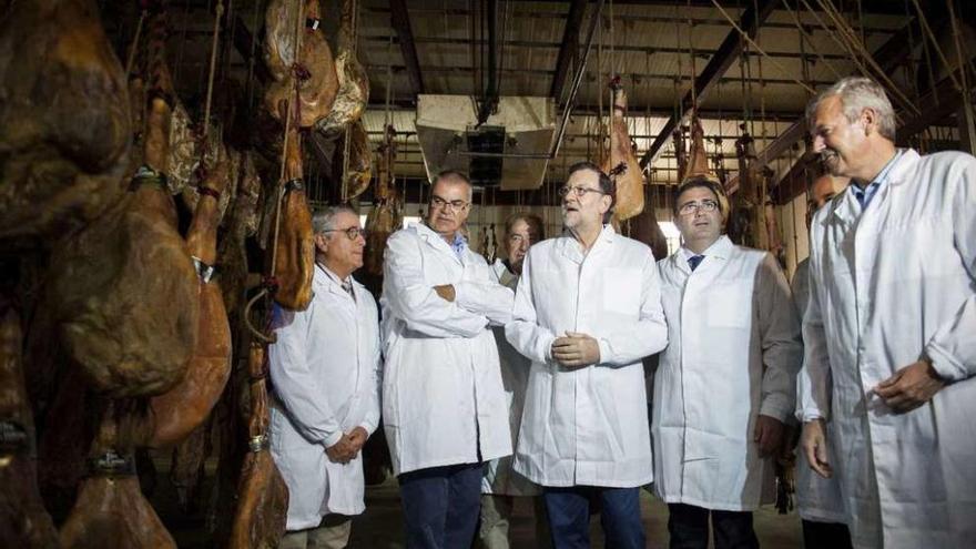 Rajoy, ayer, con Alfonso Rueda entre otros, probando el jamón de A Cañiza. // Alfredo Hernández