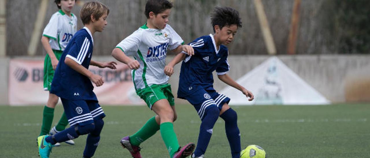 Tong controla el balón presionado por un adversario.