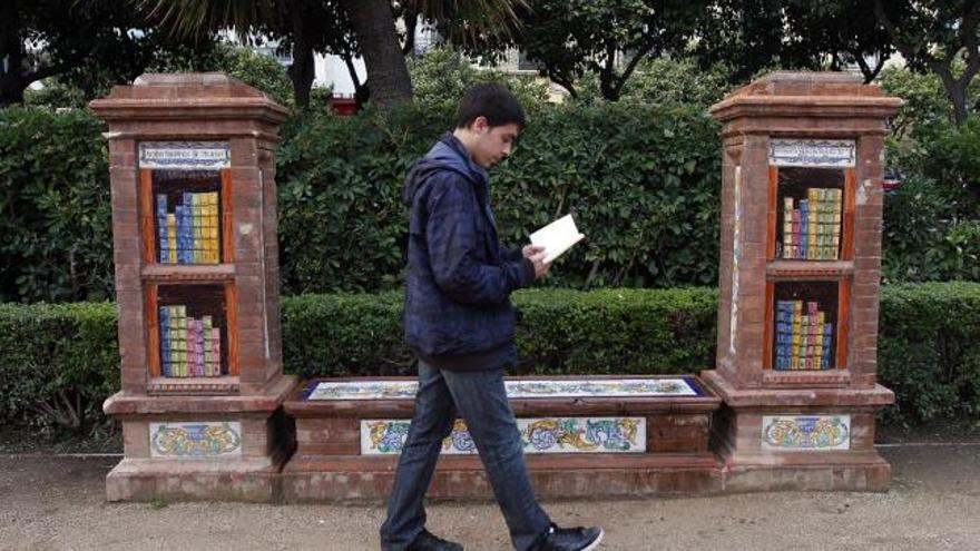 Un joven pasea con un libro delante de la denominada biblioteca de mujeres en el Parque, frente al hotel Málaga Palacio, que fue reconstruida por gentileza de Sando en 1997, con motivo del primer centenario del Parque.