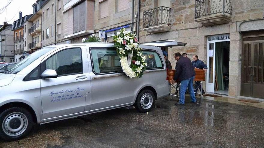 Los familiares introducen el féretro en el vehículo funerario con los restos de María del Carmen Carracedo.