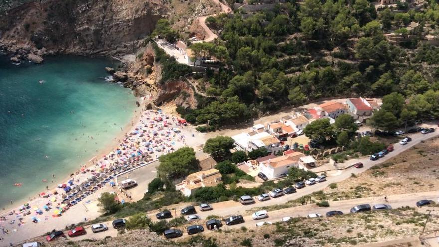 Coches aparcados en el precario vial de Pic Tort, habilitado este verano como salida de la cala.