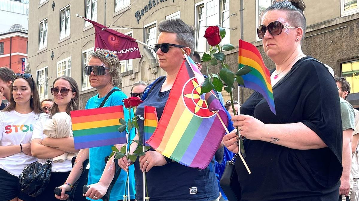 Mujeres con la bandera LGTB y flores guardan silencio tras el ataque terrorista.