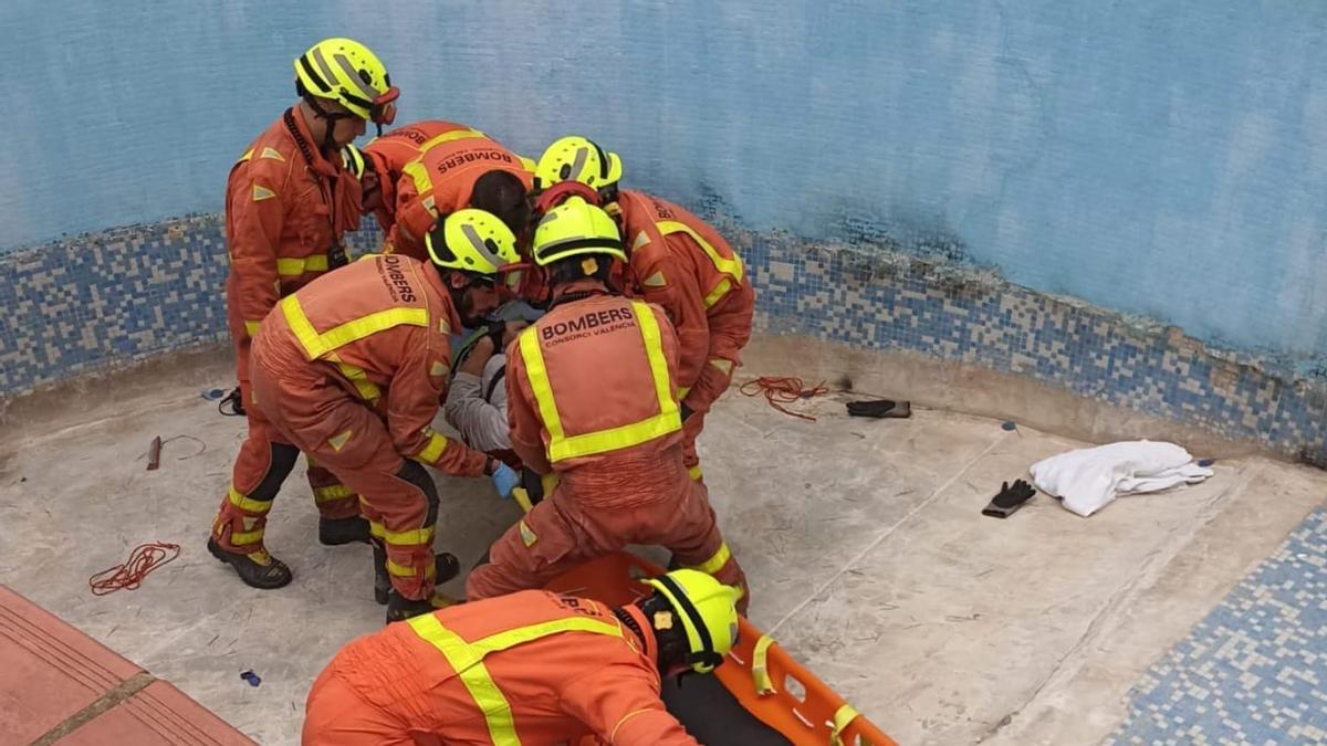 Los bomberos sacando al hombre de la piscina