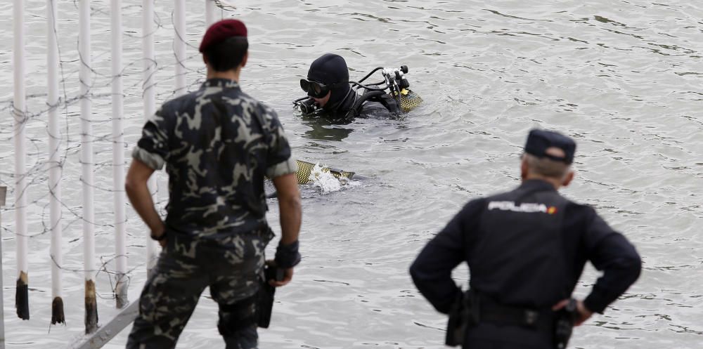 Los especialistas, que necesitan luz natural, trabajan en una zona balizada en un margen del río, apoyados por una lancha de la Policía Nacional, todo ello vigilado por agentes que impiden el acceso a la orilla de la dársena.