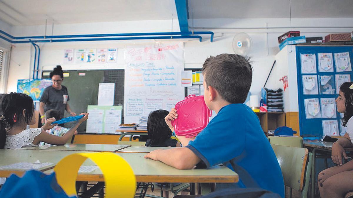 Un niño de un colegio de Cartagena se ‘abanica’ con una tapa de plástico en clase.