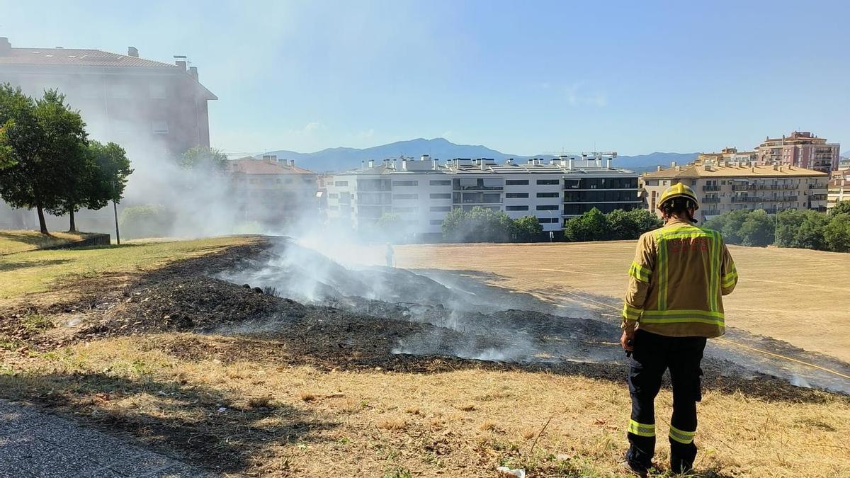 Un bomber supervisa la zona cremada pel foc de vegetació a l’avinguda de Lluís Pericot de Girona.