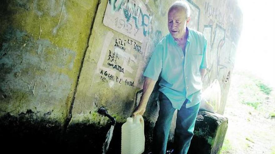 José Luis González llena una garrafa de agua en la fuente de Valparaíso.