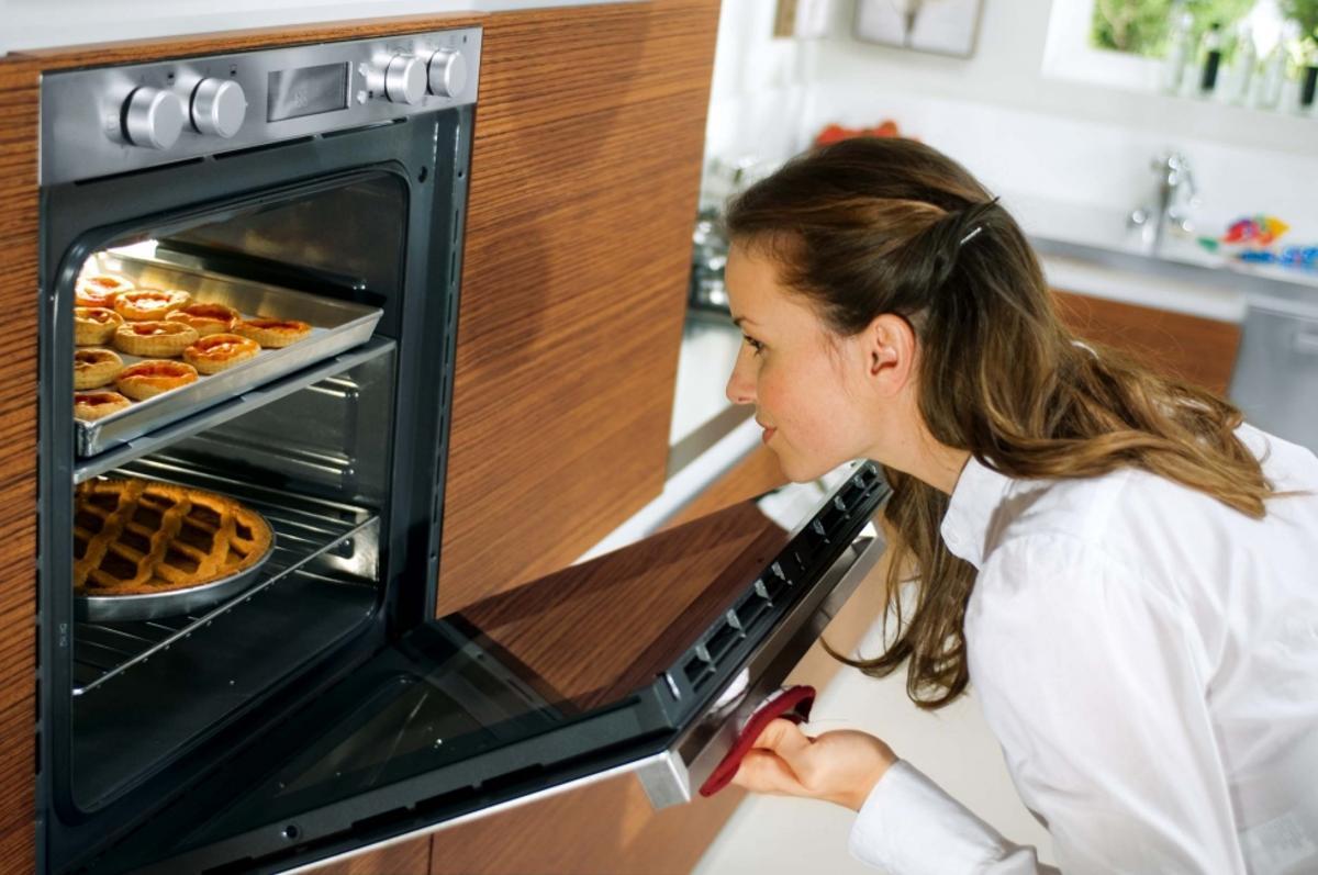 Imagen de archivo de una mujer cocinando con el horno.