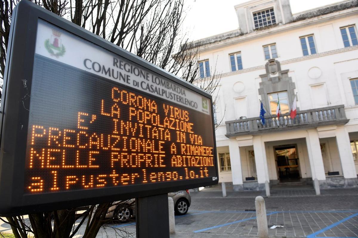 A sign warning people to stay at home is seen in the town of Casalpusterlengo amid a coronavirus outbreak in northern Italy, February 22, 2020. REUTERS/Flavio Lo Scalzo