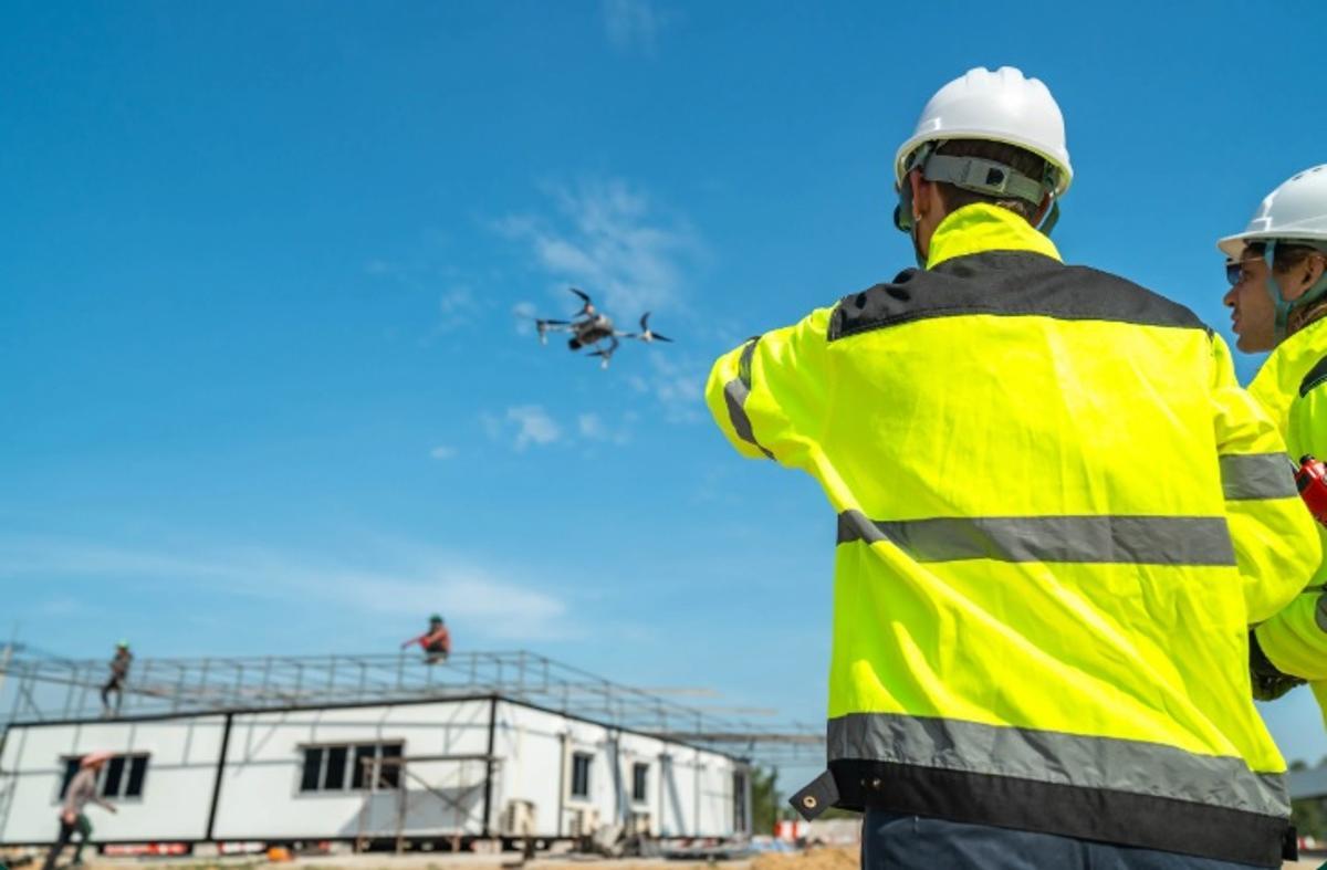 Operarios de construcción controlando un dron