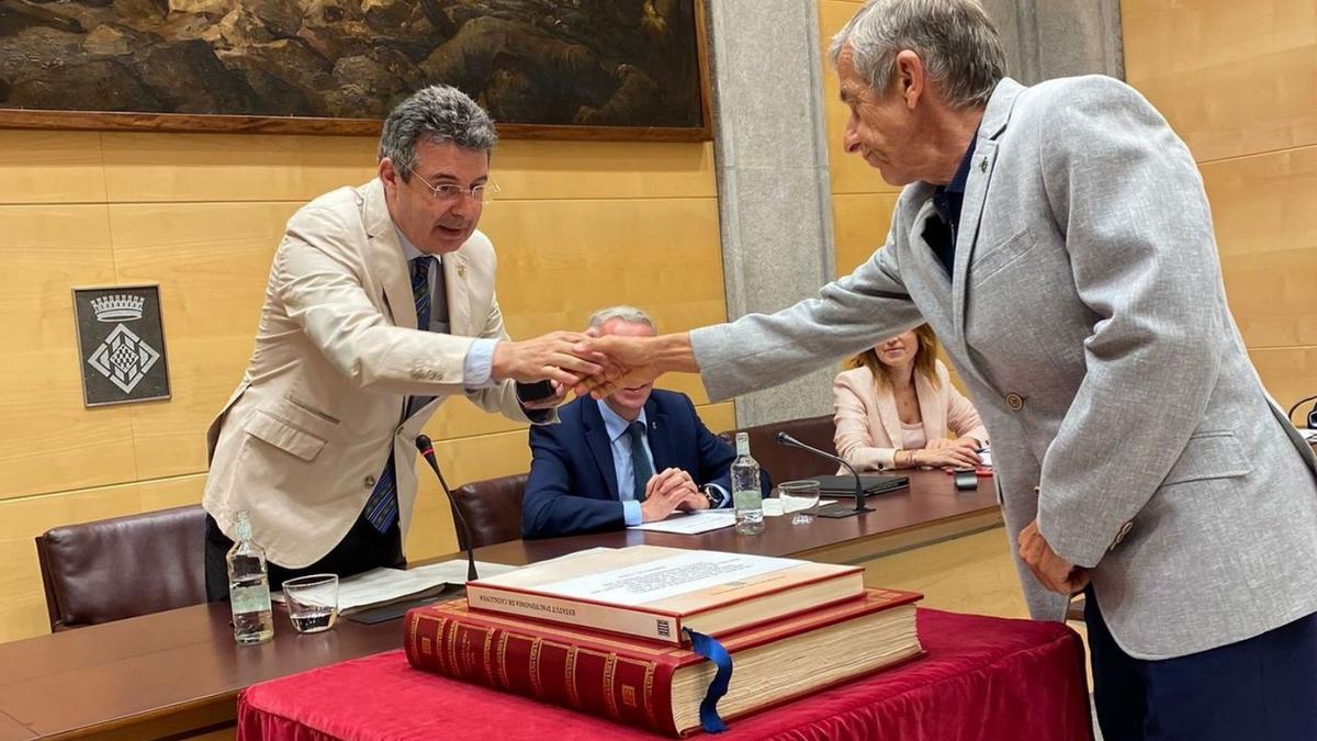 Quim Rodríguez (PSC) rep el pin de la corporació de la mà del president, Miquel Noguer.  | DIPUTACIÓ DE GIRONA