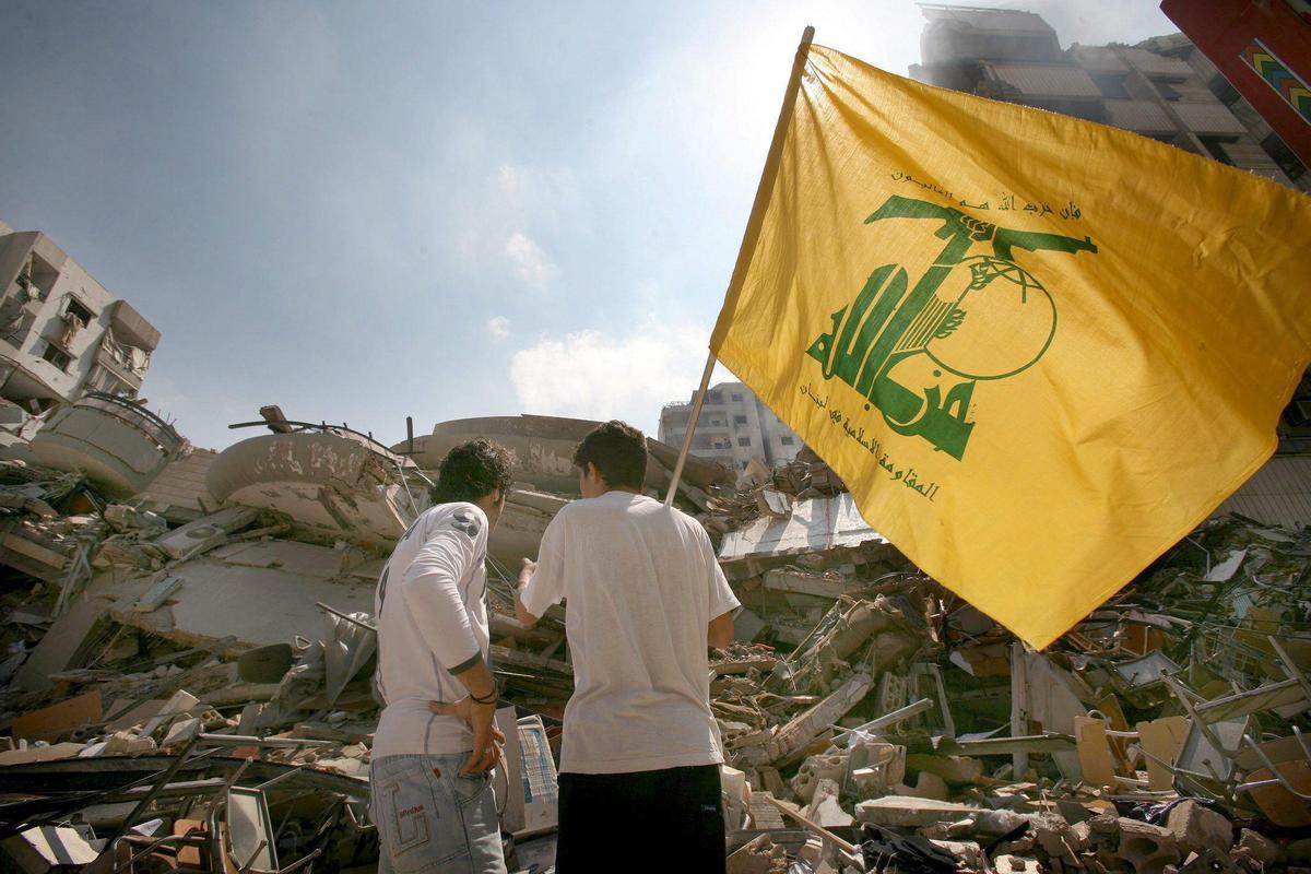 Dos jóvenes militantes de Hezbolá con la bandera del grupo militar