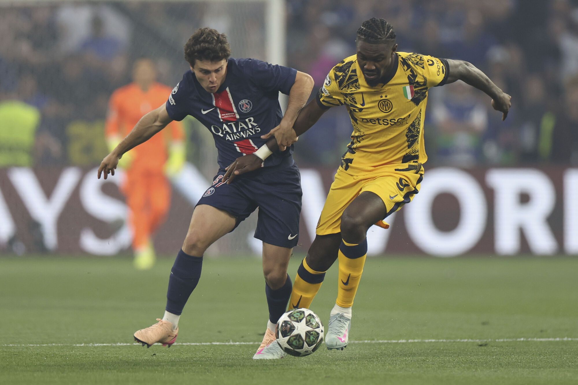 PSG's Joao Neves. left, and Inter Milan's Marcus Thuram fight for the ball during the Champions League final soccer match between Paris Saint-Germain and Inter Milan at the Allianz Arena in Munich, Germany, Saturday, May 31, 2025. (AP Photo/Alexandra Beier). EDITORIAL USE ONLY / ONLY ITALY AND SPAIN