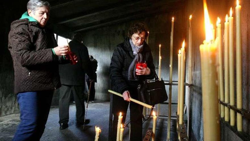 Fieles encendiendo velas. // Bernabé/Vïctor Espiño