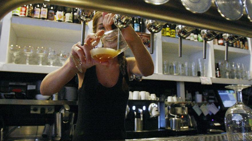 Una camarera sirve una cerveza en un local del Centro de Málaga.