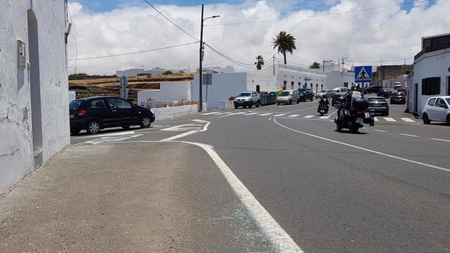 A la derecha, pequeños trozos de cristales tras el accidente en Tiagua que aún permanecen este domingo en la carretera.