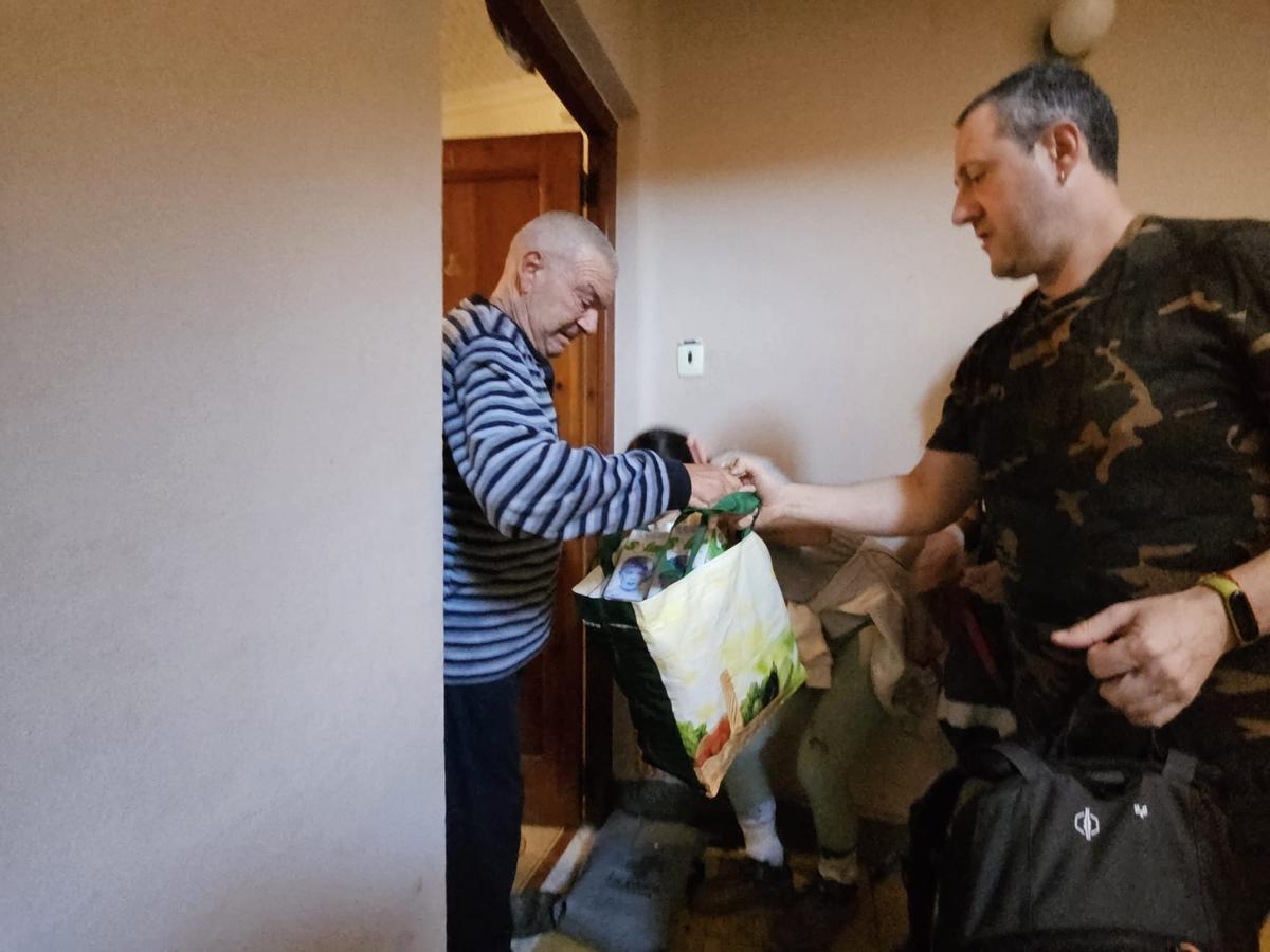 Luis Torner recibe una bolsa con alimentos en su casa.