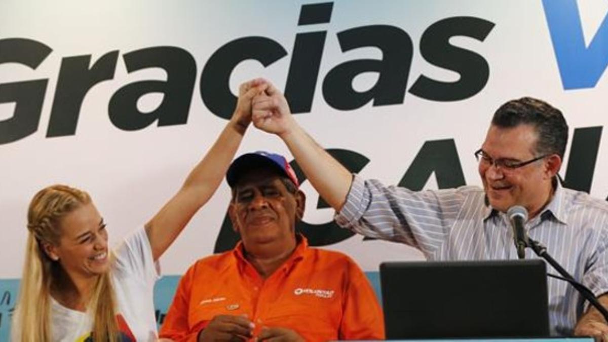Lilian Tintori (izquierda), esposa del encarcelado opositor Leopoldo López, sostiene la mano del reelegido diputado Enrique Márquez, este lunes en Caracas.
