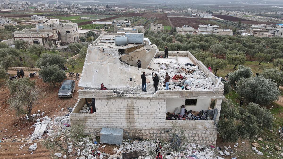 Personas inspeccionando un edificio dañado tras la operación antiterrorista de las fuerzas especiales de EEUU.