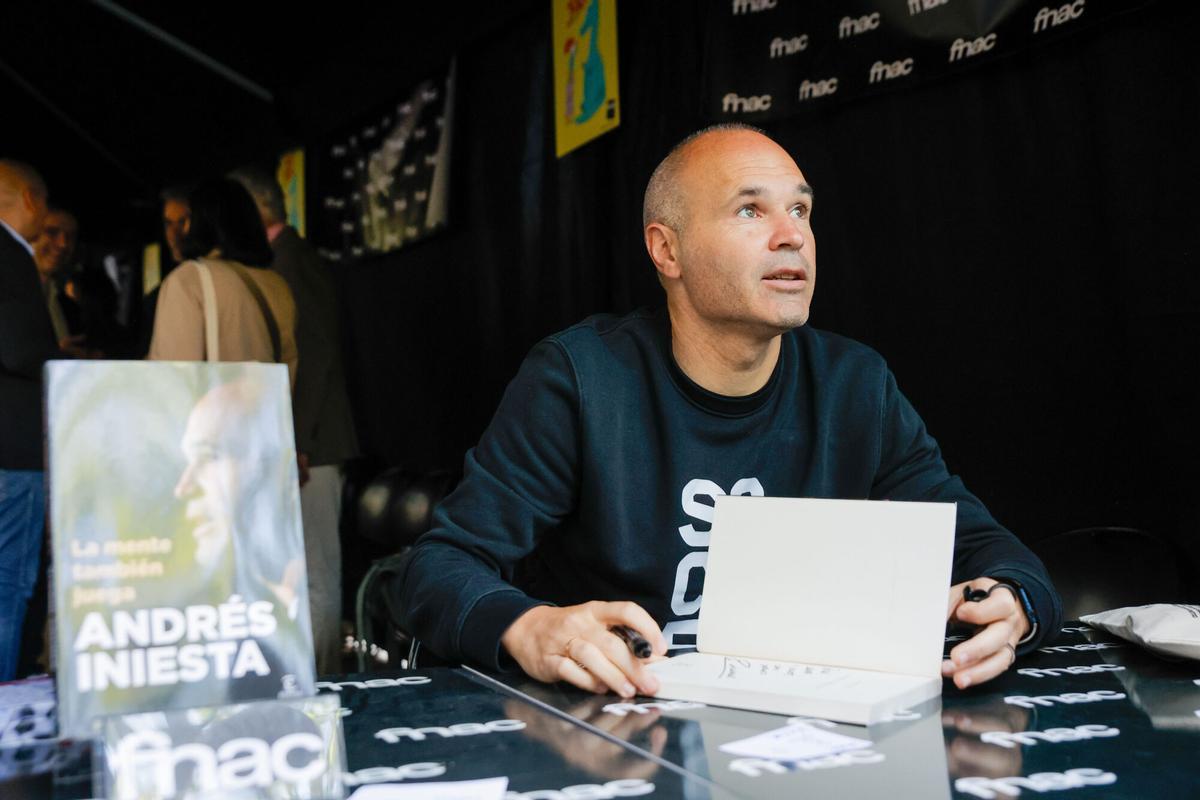 El exfutbolita, Andrés Iniesta, durante la firma de uno de sus ejemplares, en la Diada de San Jordi 2025, a 23 de abril de 2025, en Barcelona, Cataluña (España). Barcelona vuelve a vivir una nueva Diada de Sant Jordi, en la que se llena de libros y rosas, en una edición en la que crece el número de paradas profesionales de libros y superficie para buscar una mayor comodidad, hasta los 3.500 metros cuadrados en diez espacios de siete distritos de la ciudad. El Passeig de Gràcia de Barcelona aplica por primera vez un plan de autoprotección (PAU) como ocurre en otros eventos con un número elevado de asistencia. Este año, hay más paradas que el año anterior, con 400 paradas, 348 de libros y 52 de rosas, a las que se debe sumar un centenar más de libros que se ubican en las puertas de las librerías, que elevan a 500 los puestos entre libros y rosas. 23 ABRIL 2025;FERIA DEL LIBRO;FÚTBOL;ESCRITOR;DÍA DEL LIBRO Kike Rincón / Europa Press 23/04/2025. ANDRES INIESTA;Kike Rincón