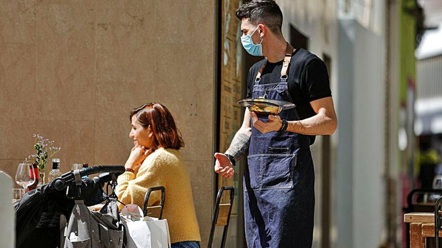 Un camarero atiende a unos clientes en Eivissa. | T. E.