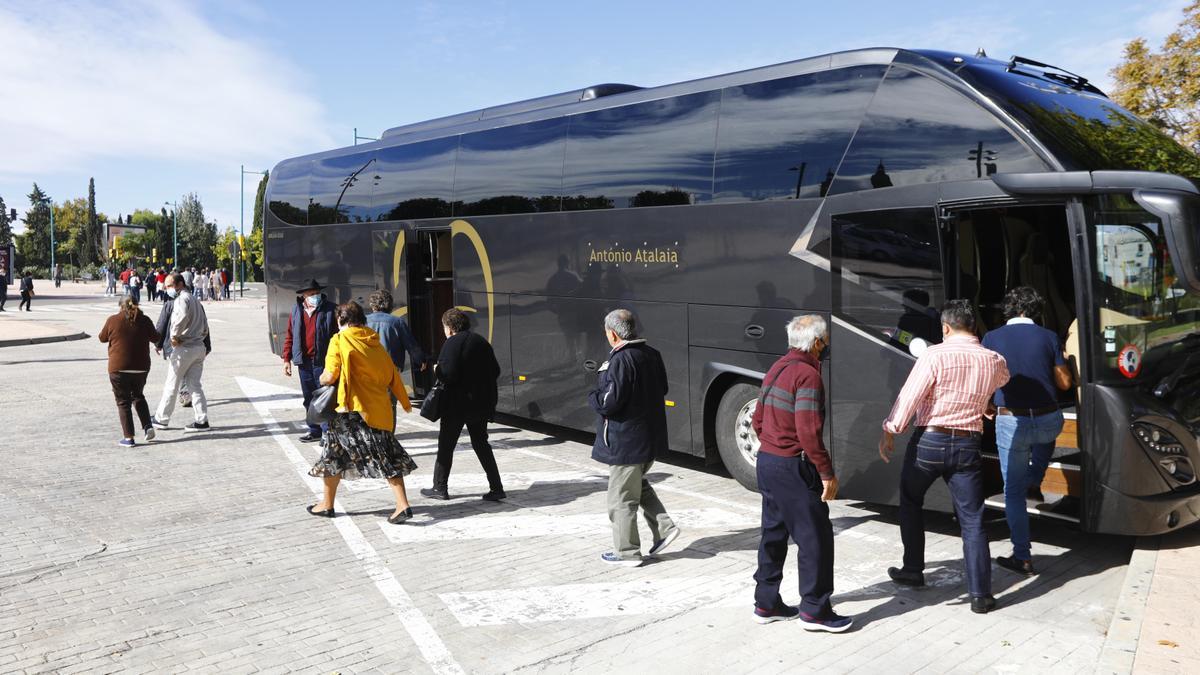 Varios turistas bajan de un autobús en el párking de la arboleda de Macanaz en Zaragoza.