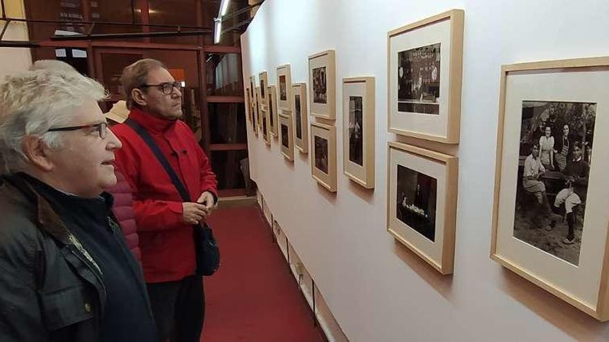 Asistentes a la muestra, ante algunas de las fotografías expuestas.