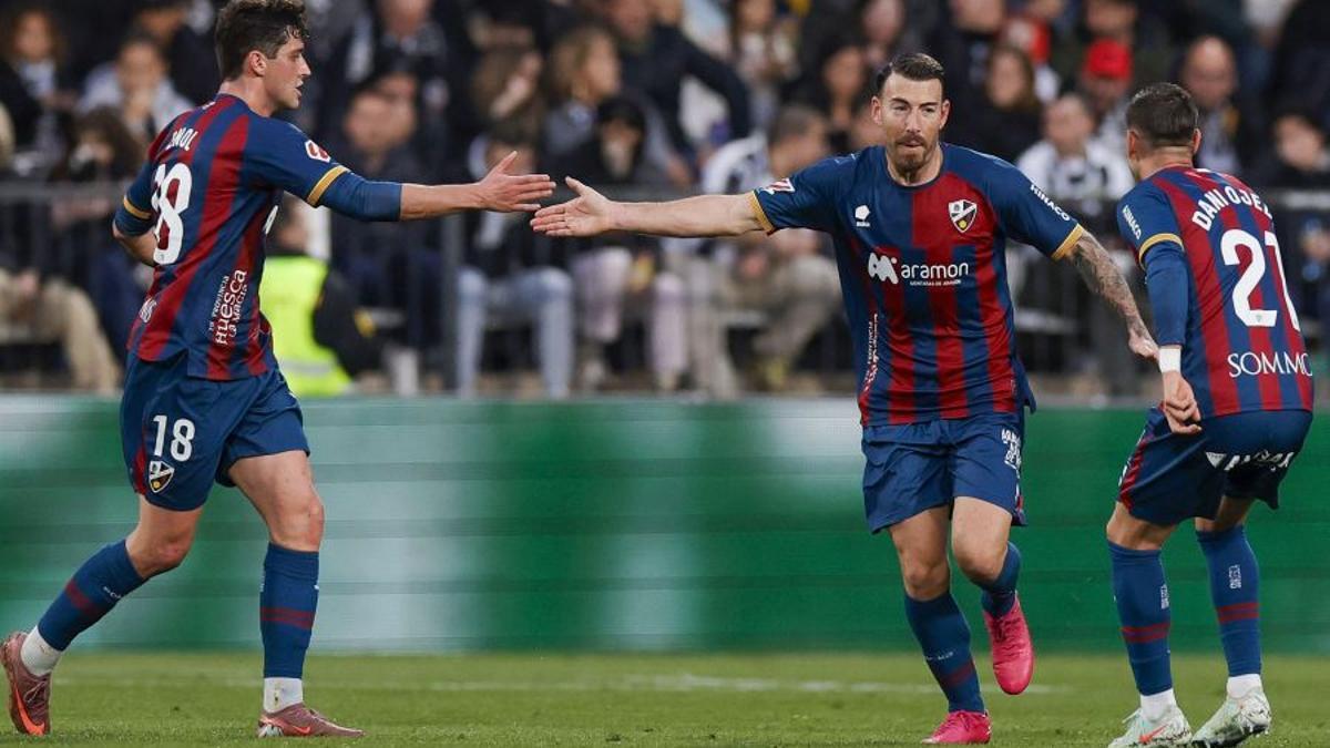 Sergi Enrich celebra el único gol del Huesca junto a Enol.