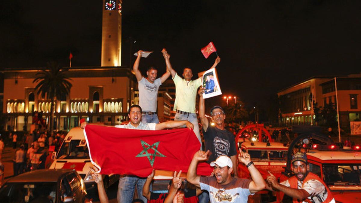 Partidarios de Mohamed VI muestran una foto del rey de Marruecos y una bandera del país en Casablanca, tras el discurso del monarca.