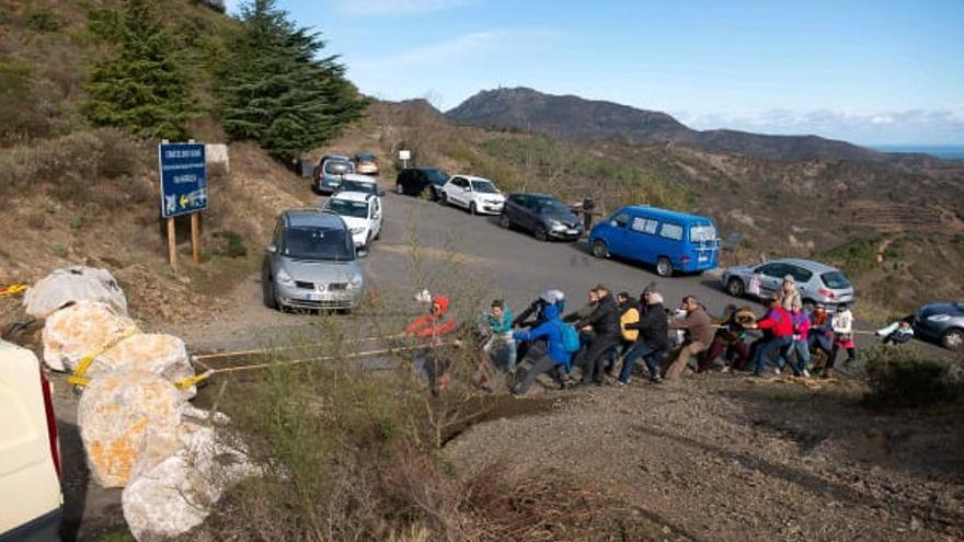 Un grup de veïns estirant amb cordes les roques