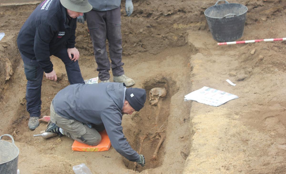 Varias persoas do grupo da USC exhumando os restos dun cadáver nunha fosa común.