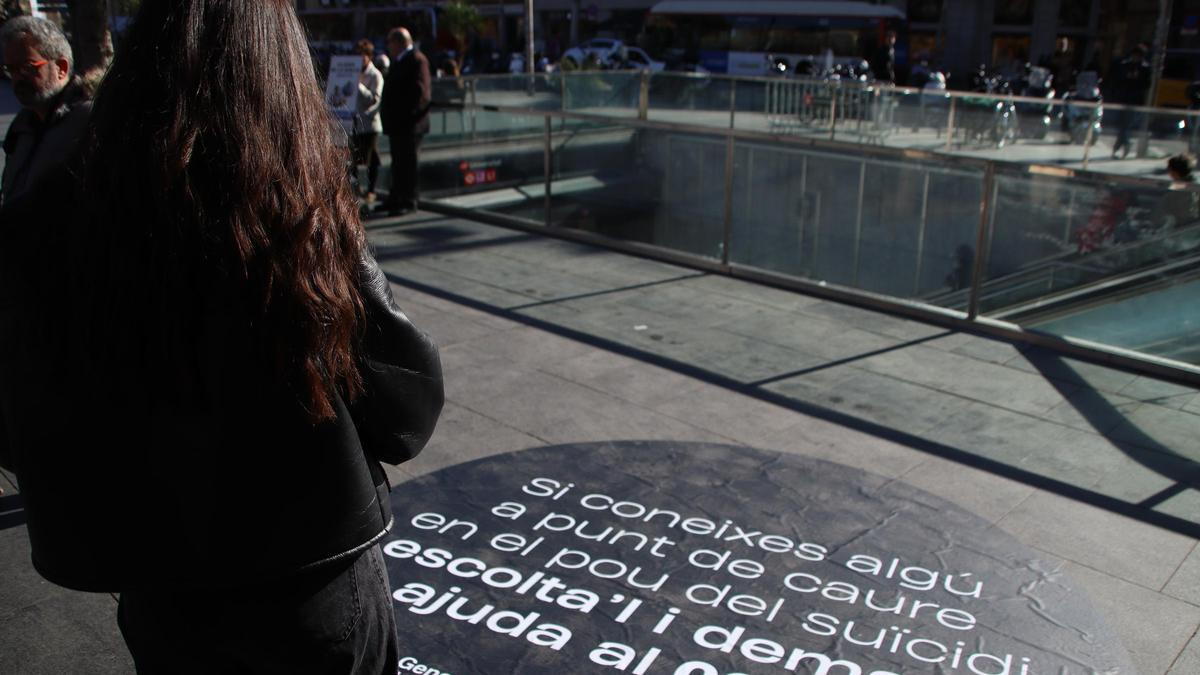 Una joven lee un mensaje de la campaña de Salut contra el suicidio.