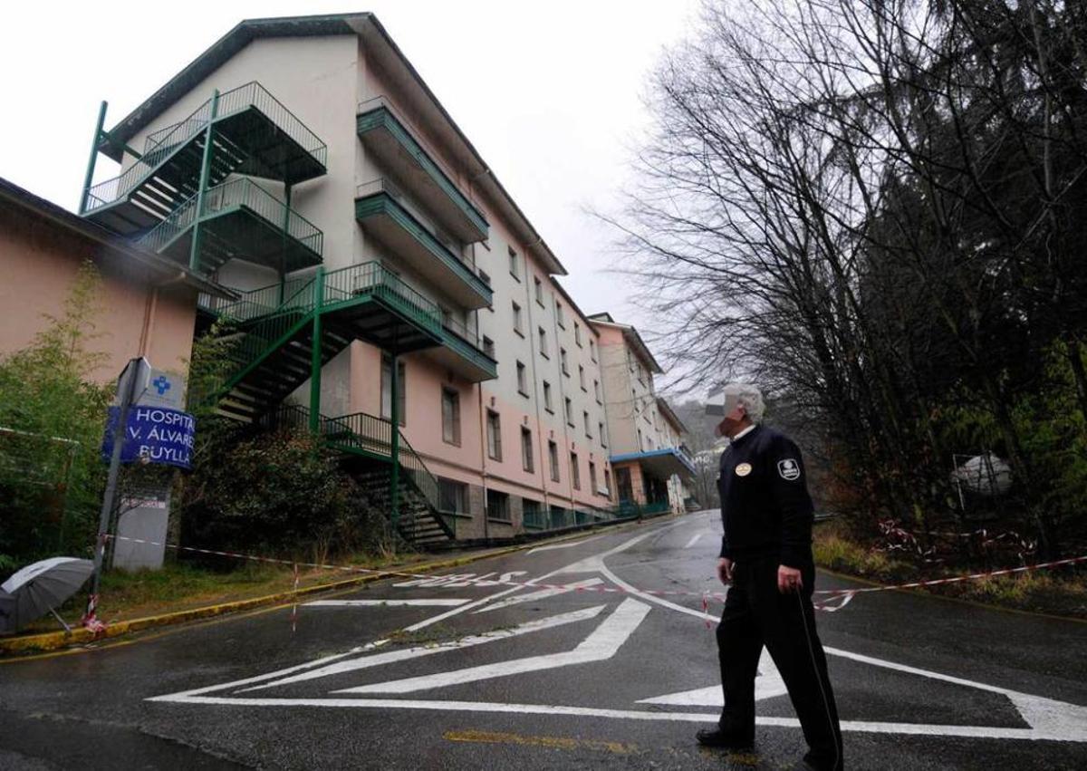 Un guardia de seguridad, ayer, ante las instalaciones del viejo hospital Álvarez Buylla de Mieres.