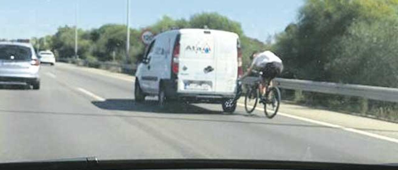 Un ciclista agarrado a una furgoneta, el jueves, en la autopista de Llucmajor.