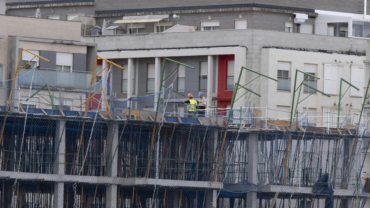 Operarios trabajando en la construcción de un bloque de viviendas en Xàtiva.