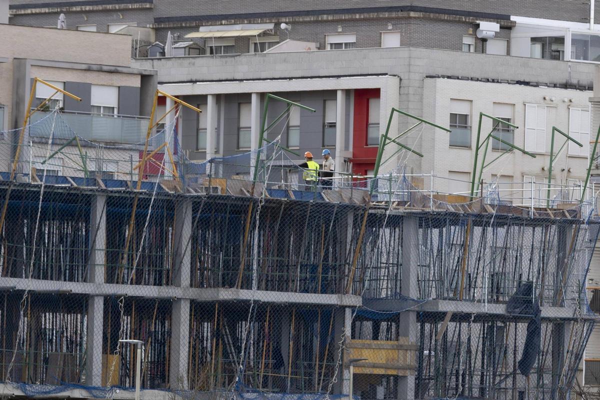 Operarios trabajando en la construcción de un bloque de viviendas en Xàtiva.