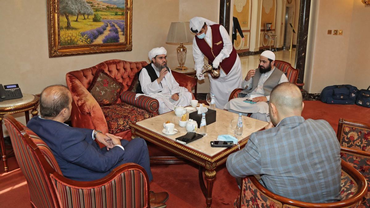 El exenviado de los talibanes a Arabia Saudí, Shahabuddin Delawar (C), toma un café antes de una reunión con diplomáticos extranjeros en Doha, capital de Qatar, el 12 de octubre de 2021.