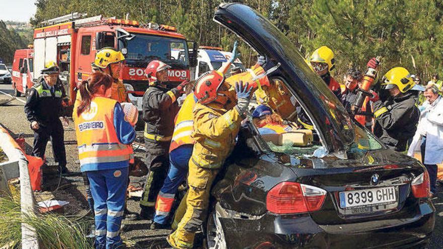 Los bomberos retiran el techo del BMW para rescatar al fallecido. En el recuadro, Miguel Martínez Romero.  // Gustavo Santos