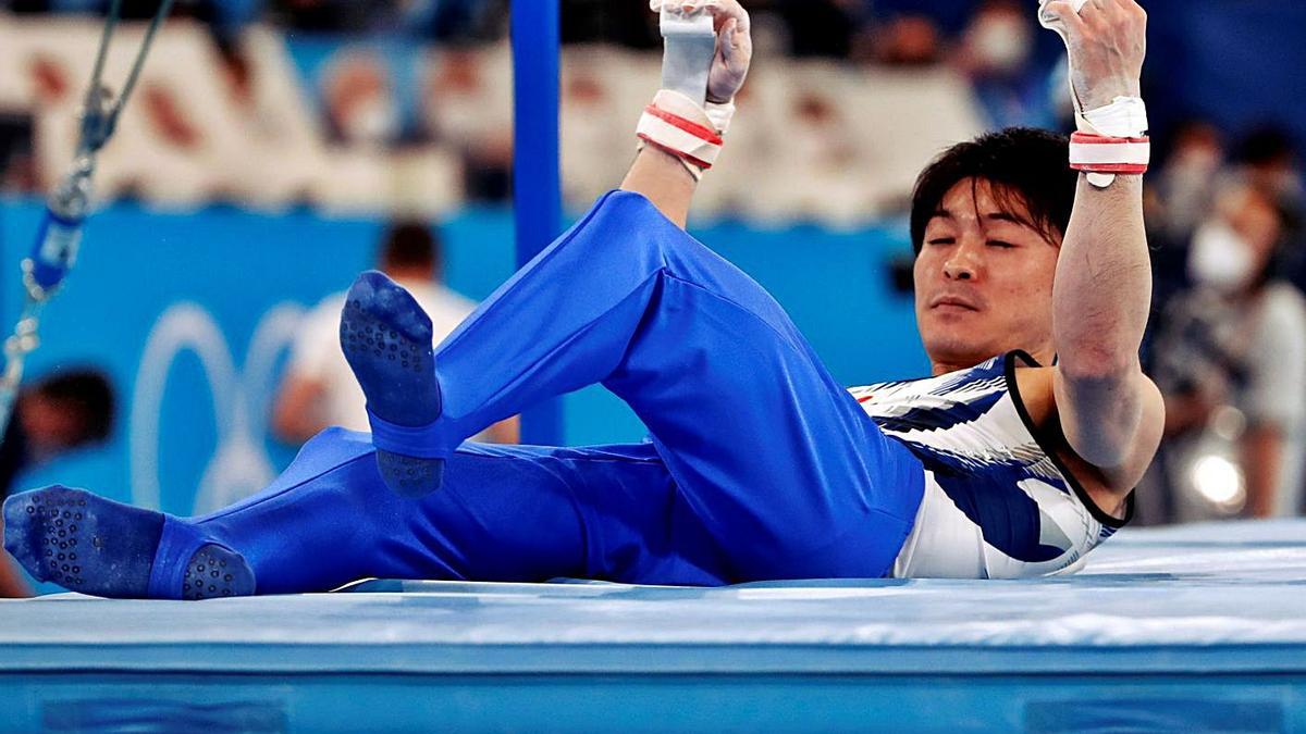 Uchimura, en el suelo después de caerse de la barra. // EFE