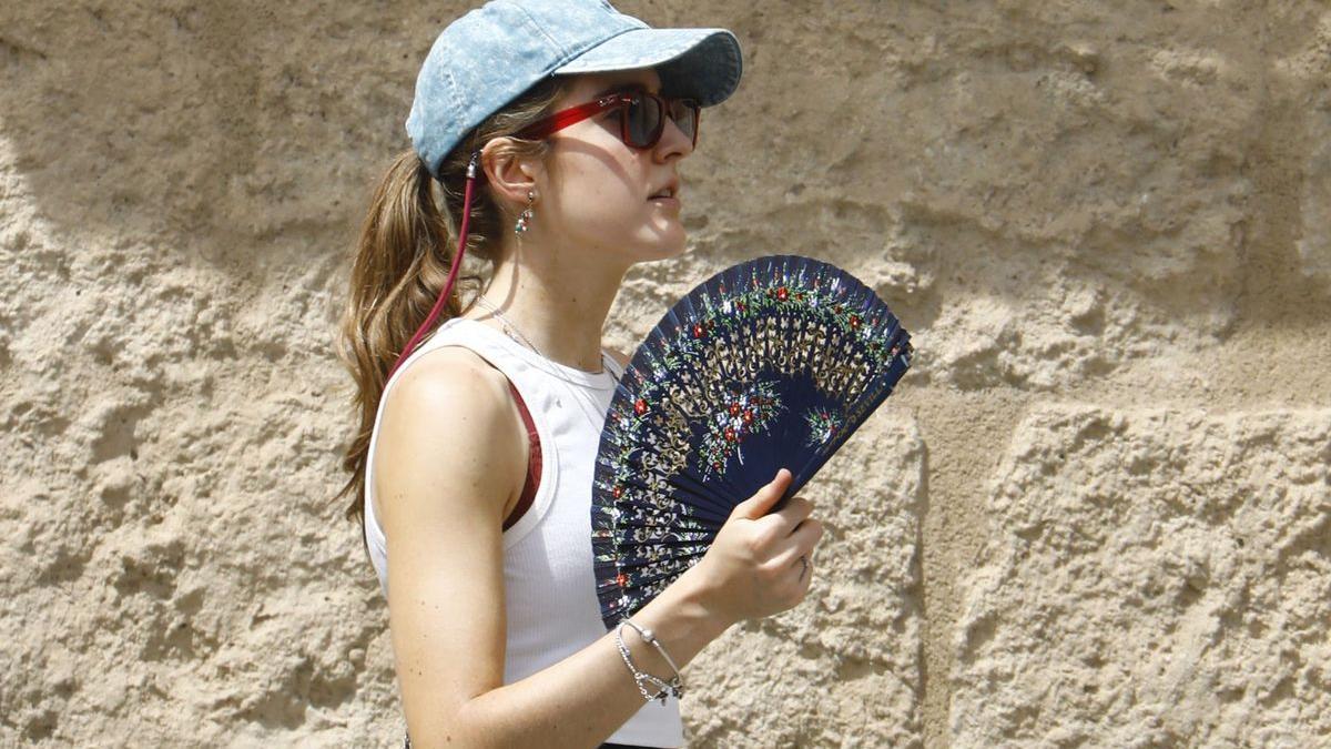 Una turista se abanica para aliviar las altas temperaturas durante un paseo por el casco antiguo de Córdoba.