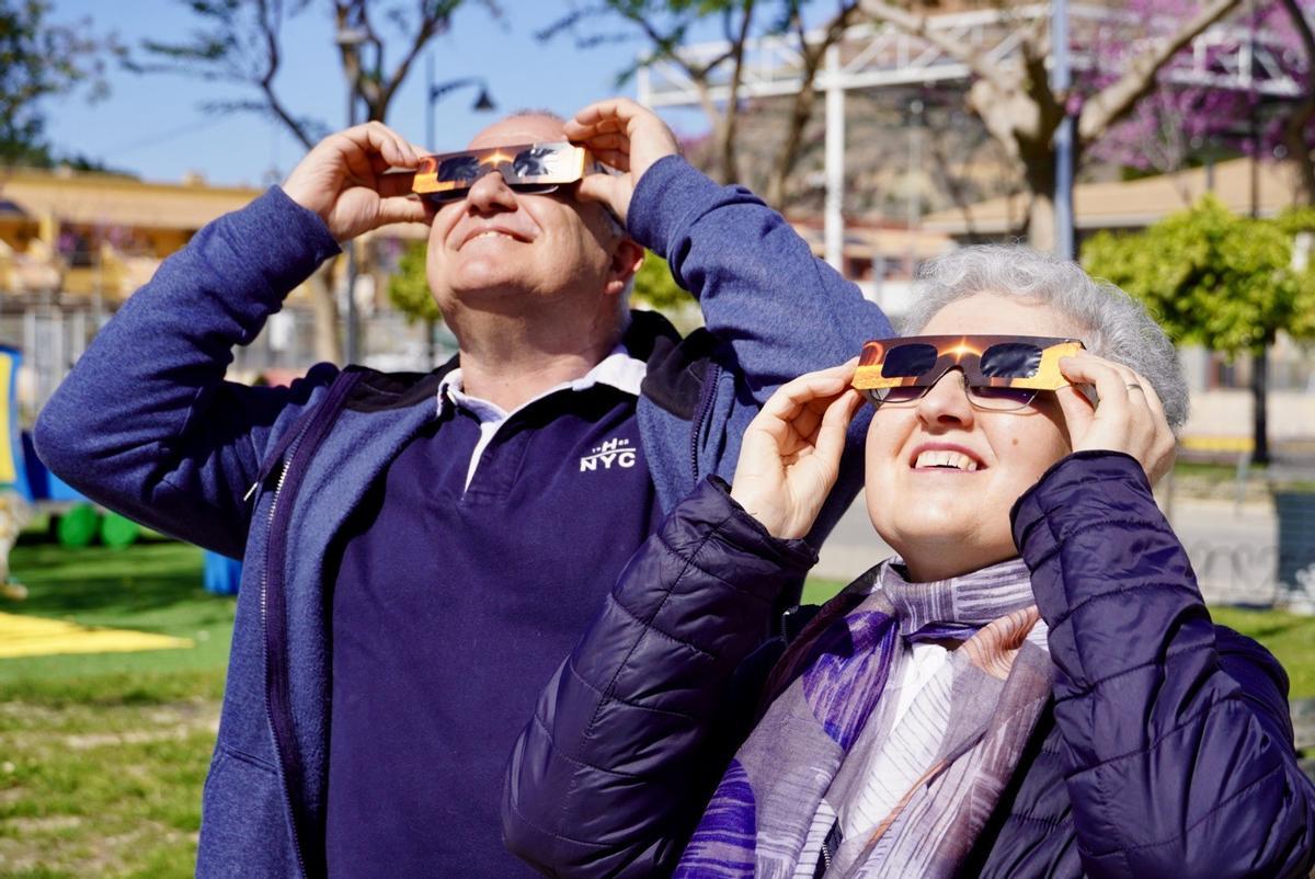 Una pareja mirando al cielo durante un eclipse.